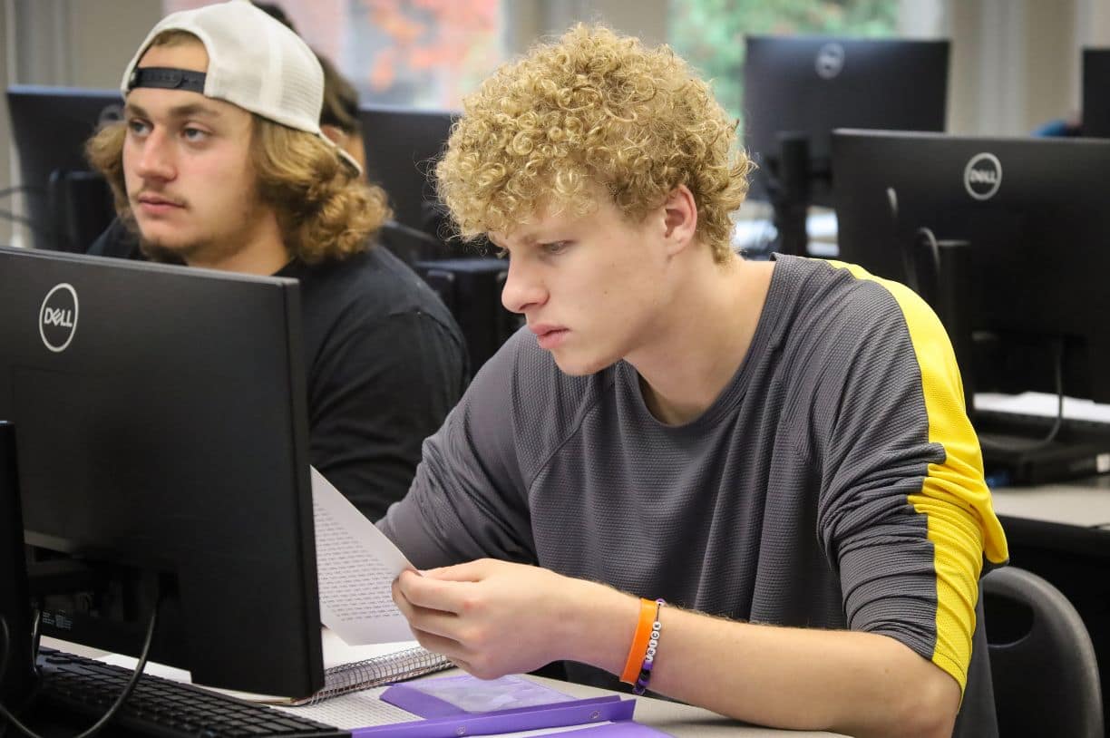 yearbook photo from the past with students on fire truck in black in white