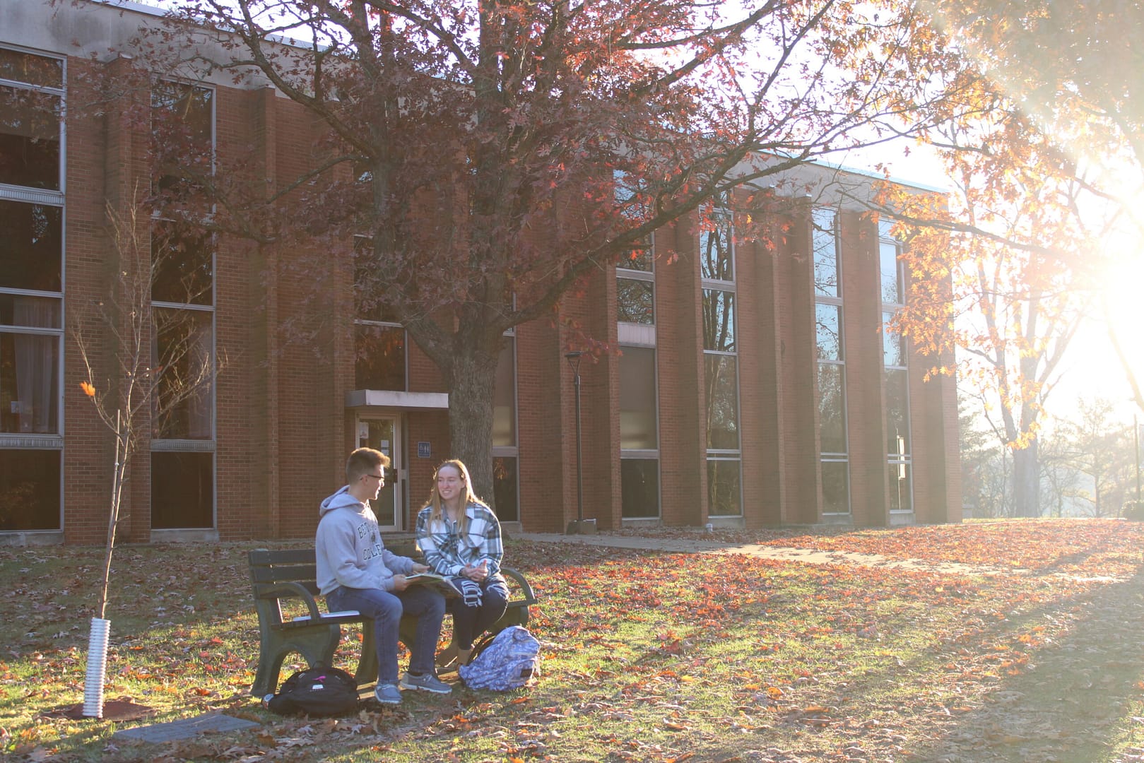 Student holding up a Roll Bison sign and smiling at the camera