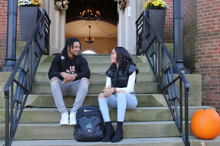 students talking on a bench outdoors