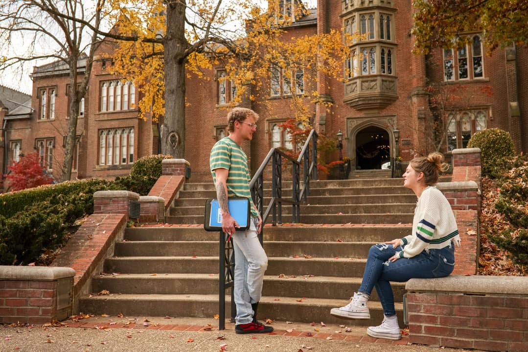 students talking outside by stairs