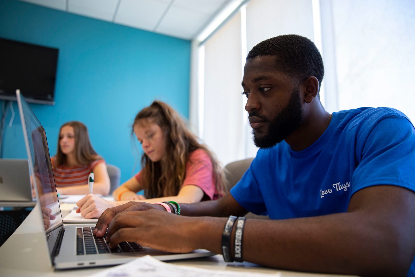 male student in class on laptop